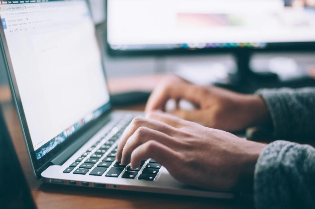 Image of hands typing on a laptop with a Google Doc open.